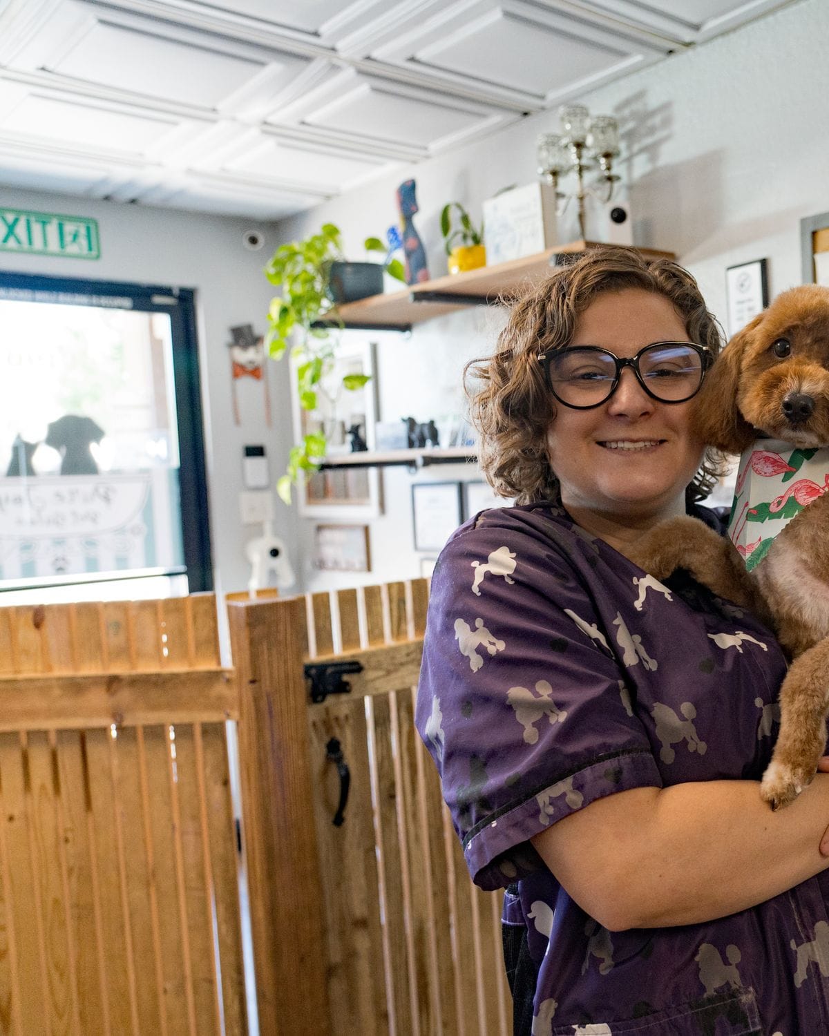A Pure Joy stylist holding a freshly groomed dog at the Atwater salon