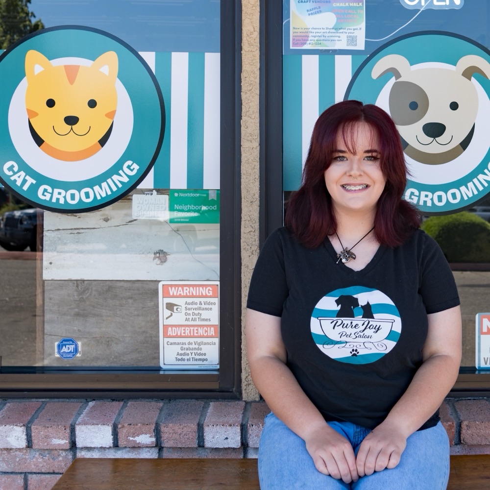 Kaylee, bather at Pure Joy Pet Salon, smiling outside the Atwater salon