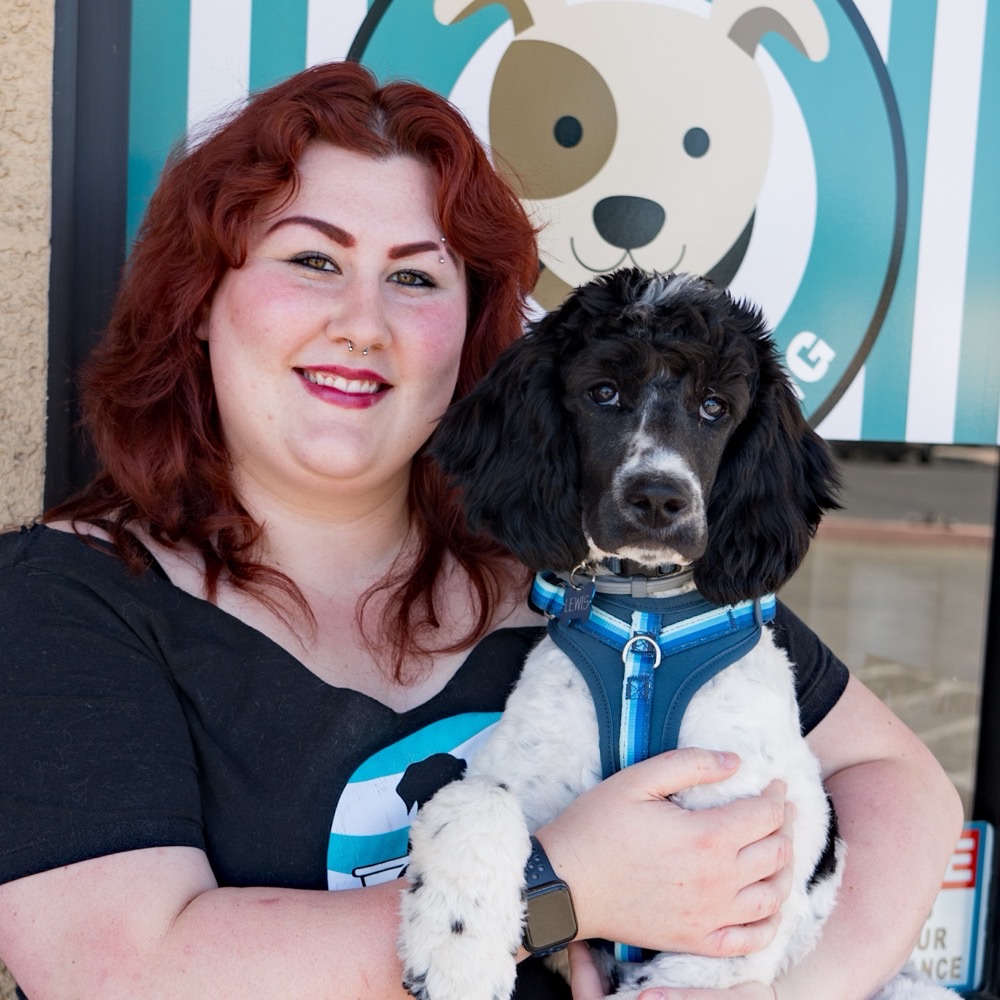 Natalie, pet stylist at Pure Joy Pet Salon, holding a dog outside the Atwater salon